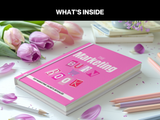 Pink book titled 'The Marketing BUR Book' on a white surface with tulips and pencils.
